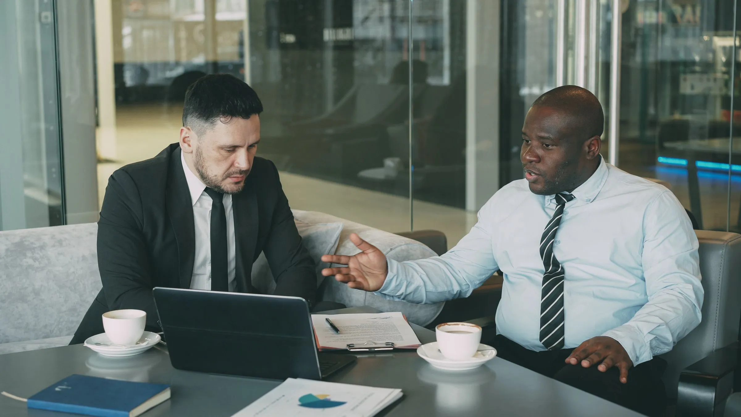 Two executives in discussion at a meeting table